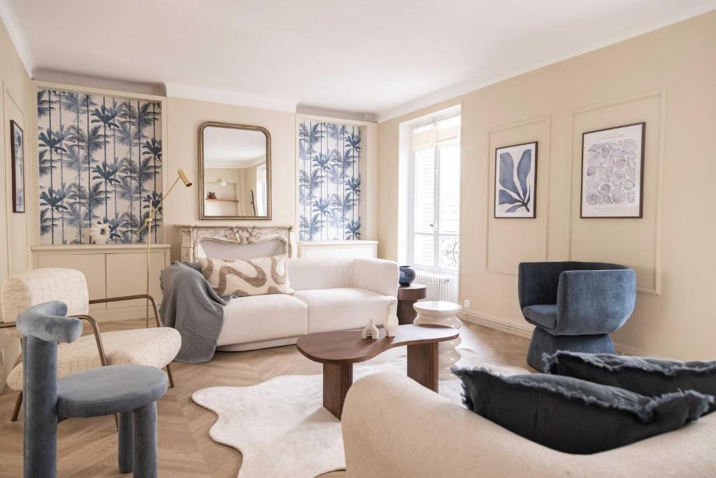 un salon avec un canapé blanc et des chaises dans l'établissement Chic apartment - 5BR-10P - Grenelle-Eiffel Tower, à Paris