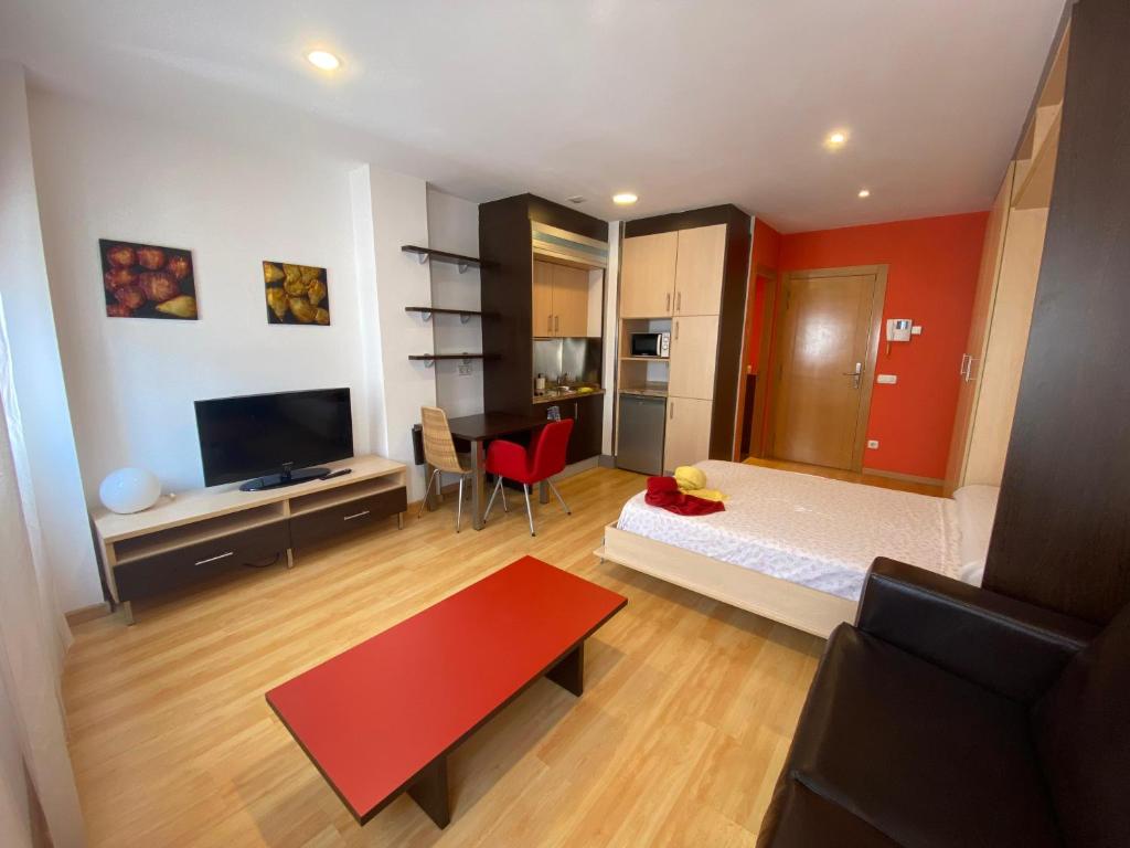 a bedroom with a bed and a red wall at Estudio Céntrico B1 in Oviedo