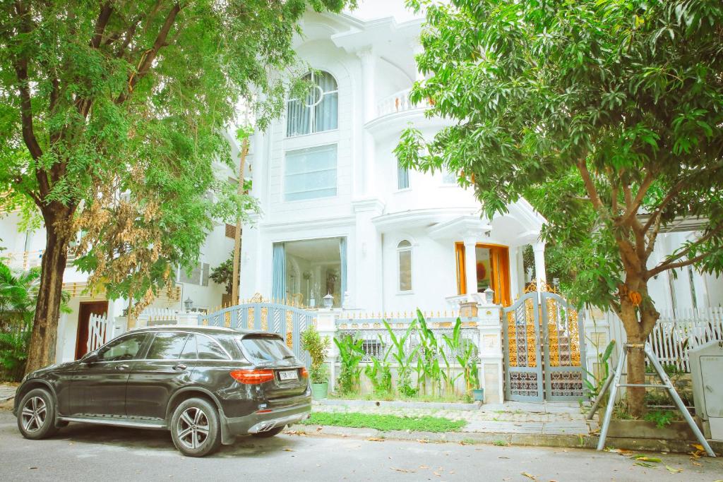 a black car parked in front of a white house at Benzen villa in Nha Trang