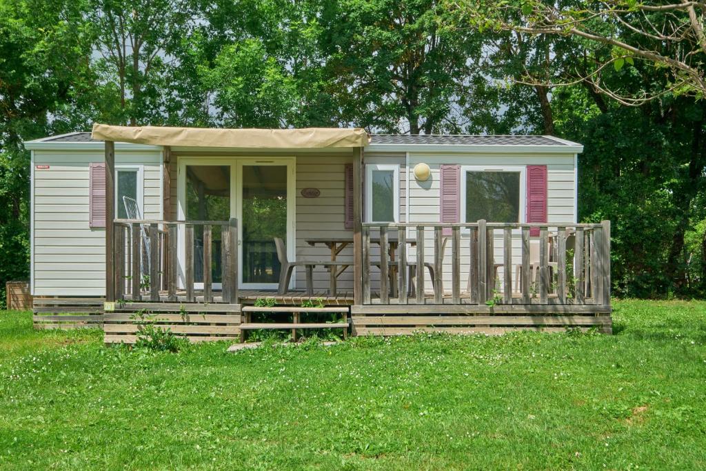 Cette petite maison dispose d'une terrasse couverte et d'une table. dans l'établissement Mobil Home 4 personnes 207, à Mens