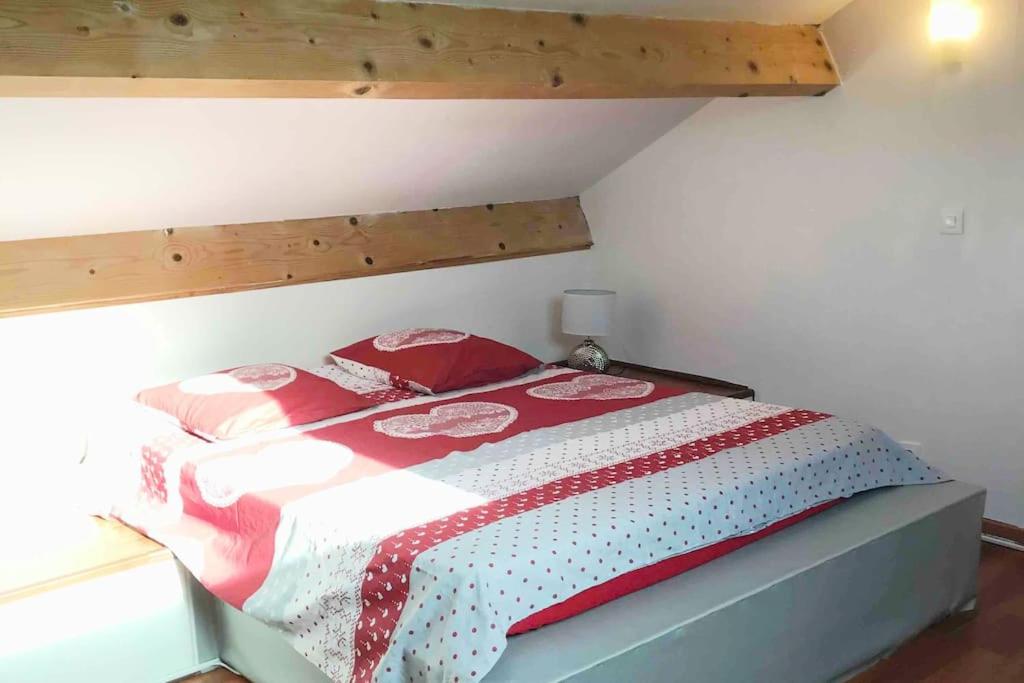 - une chambre dotée d'un lit avec une couverture rouge et blanche dans l'établissement Petit Cocon, à Saint-Laurent-de-la-Prée