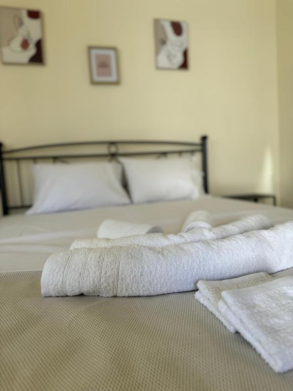 two towels are laying on a bed in a bedroom at Airpoint Apartments in Artemida