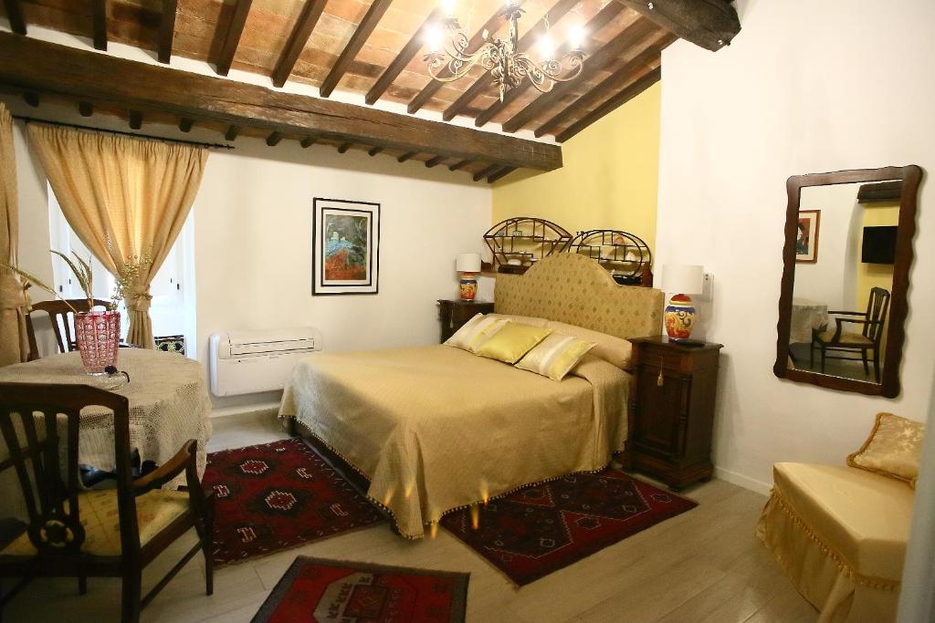 sypialnia z łóżkiem, stołem i lustrem w obiekcie B&b Porta Nuova w mieście Todi