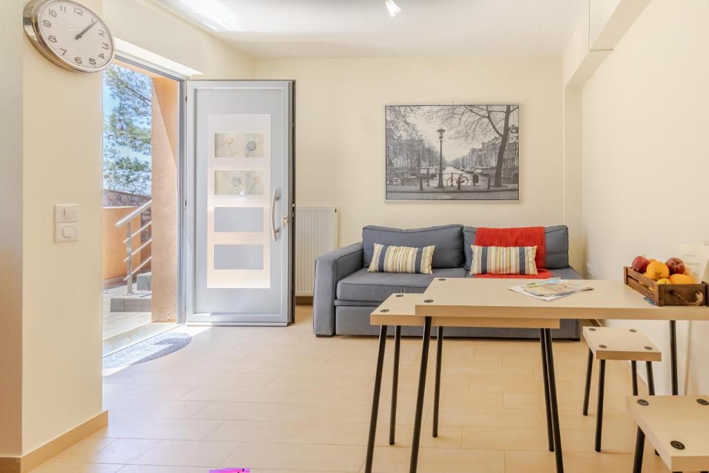 ein Wohnzimmer mit Sofa und Tisch in der Unterkunft Cozy cottage in Áyios Dhimítrios