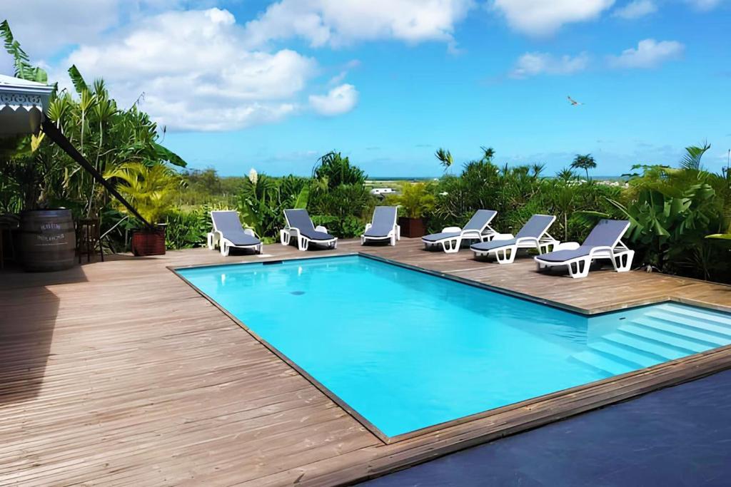 Anse-BertrandにあるVilla Catalunyaのラウンジチェア付きのスイミングプール、スイミングプールバイザーバイザー