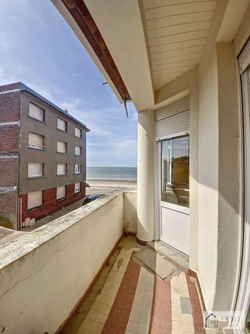 Elle comprend un balcon offrant une vue sur un bâtiment et l'océan. dans l'établissement Balcon Marin des Peupliers, à Bray-Dunes