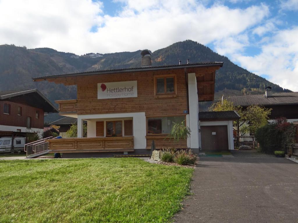 a large wooden house with a mountain in the background at Holiday Home Hettlerhof in Maishofen