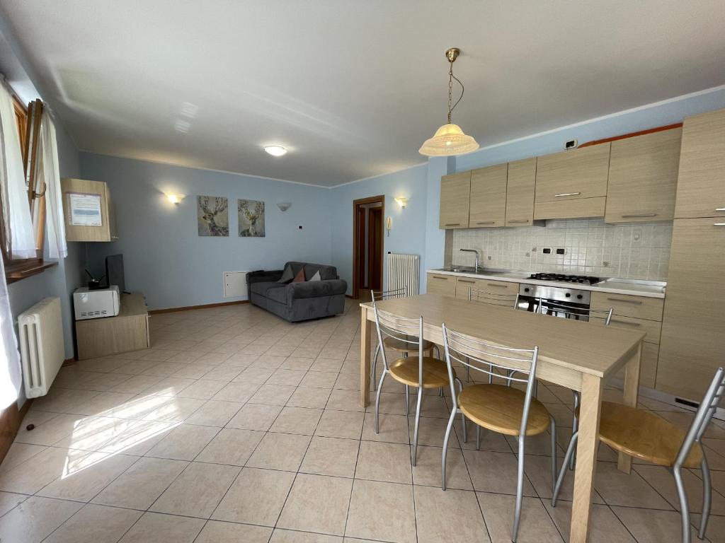 a kitchen and living room with a table and chairs at Residence Valentino in Pinzolo