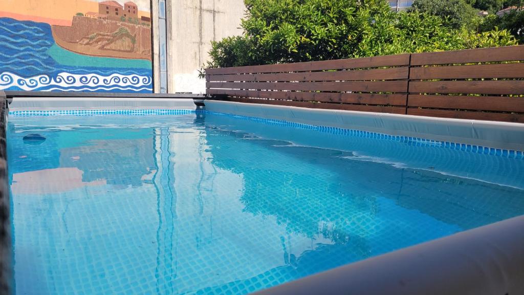 a swimming pool with a bench and blue water at Hostel Center in Ulcinj