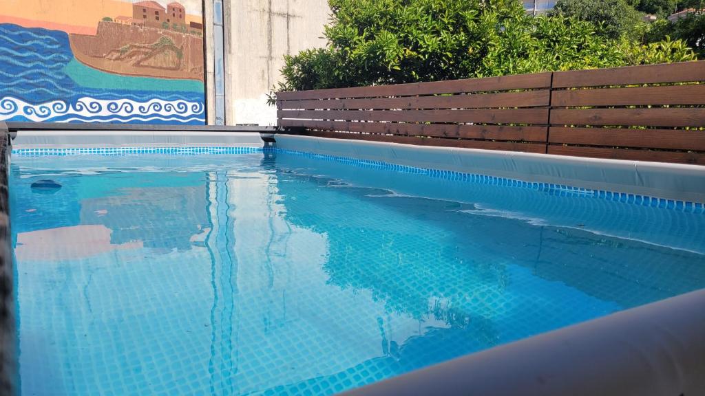 ウルツィニにあるHostel Centerの青い水とベンチ付きのスイミングプール