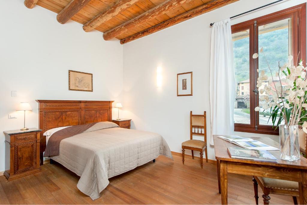 a bedroom with a bed and a desk and a window at B&B Borgo Castello in Marostica