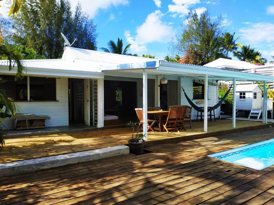 une maison blanche avec une terrasse et une piscine dans l'établissement Villa zen Bali piscine privée 3 chambres lotissement les hauts de la vallée d'or, à Saint-François