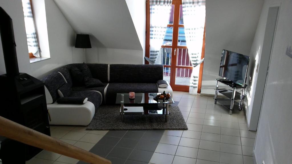 a living room with a couch and a tv at Ferienwohnung Holtenau in Altenholz