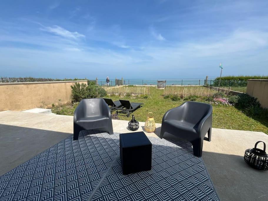 un groupe de chaises assises sur un tapis avec la plage dans l'établissement Superbe maison en front de mer, à Ver-sur-Mer