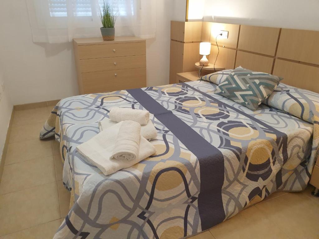 een slaapkamer met een bed met handdoeken erop bij Holidaytorremar-84-MED021 in El Borseral