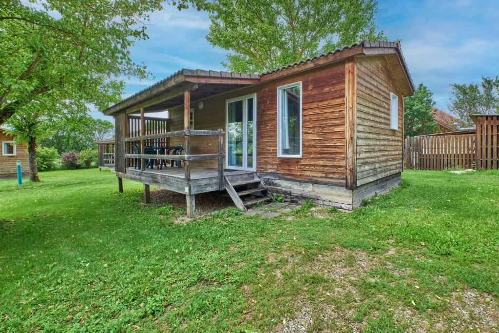 une petite maison avec une grande terrasse couverte sur une cour dans l'établissement Chalet 5 personnes 302, à Mens