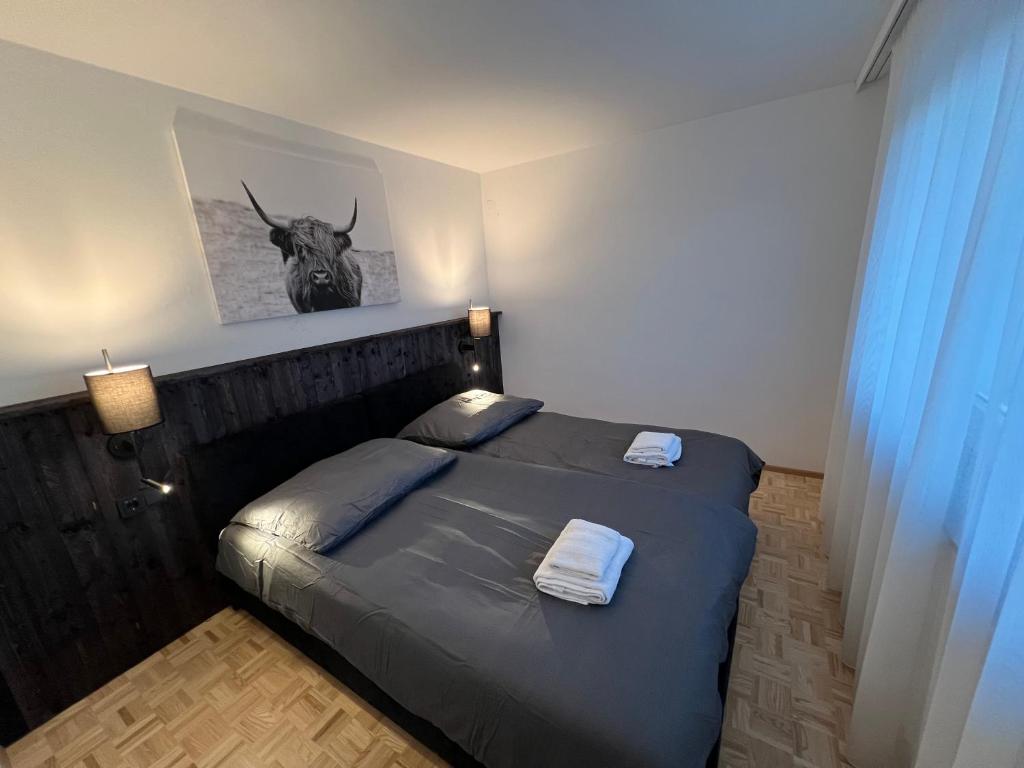 a bedroom with a bed with a picture of a deer on the wall at rs44 Apartments über den Dächern von Bregenz in Bregenz