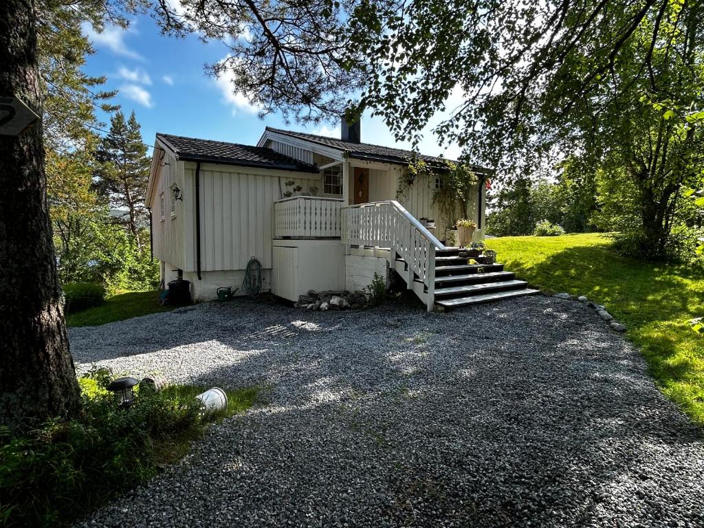 Una pequeña casa blanca con porche y escaleras. en Casa Blanca, en Å i Åfjord