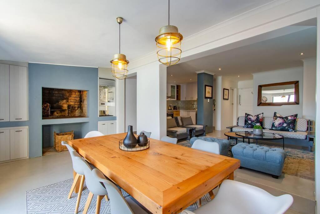 a living room with a wooden table and chairs at Chic, Cozy, Modern, Secure and Centrally Located in Cape Town
