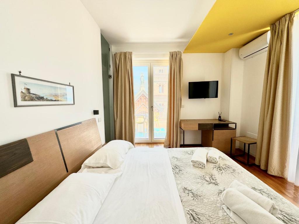 a bedroom with a large bed and a television at La Gaetana in Gaeta