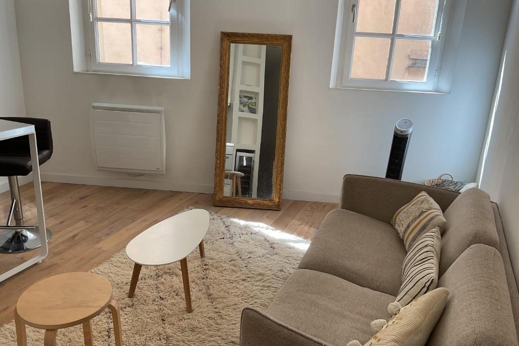un salon avec un canapé et un miroir dans l'établissement Nice love nest in the heart of Aix-en-Provence, à Aix-en-Provence