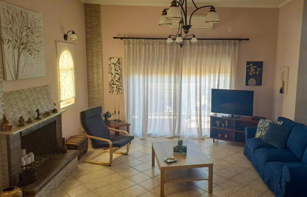 a living room with a blue couch and a tv at Panorama View Aigio in Aígio