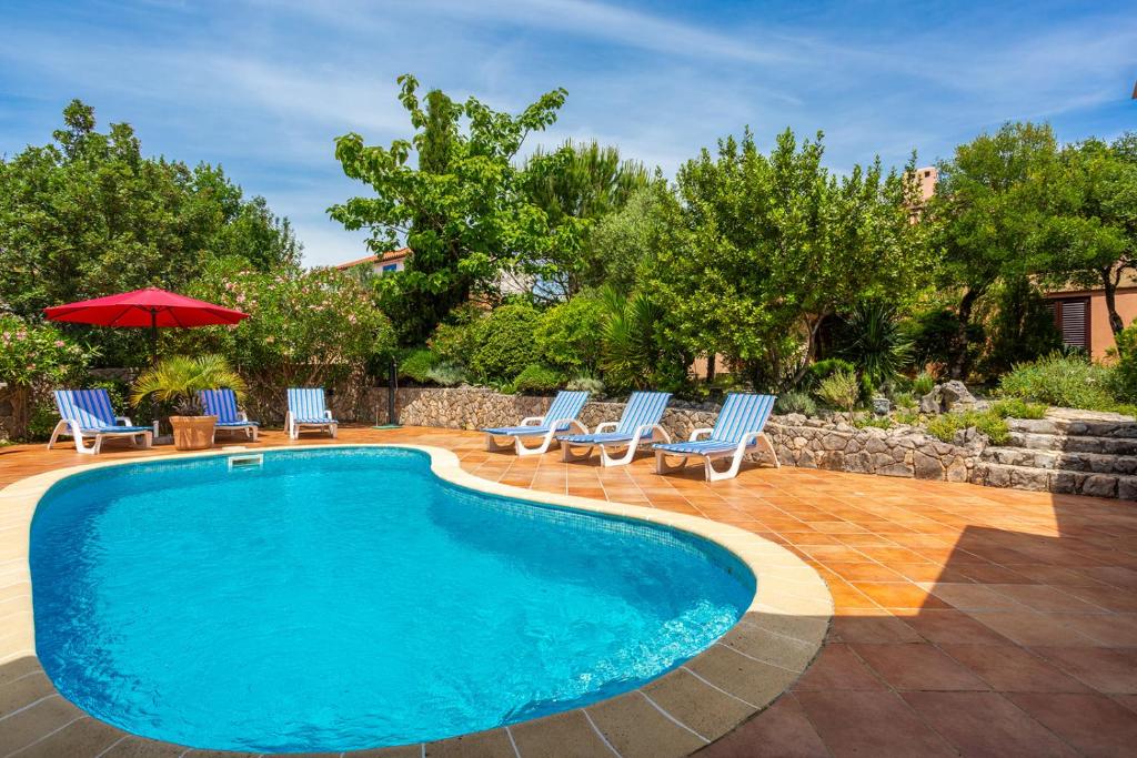 basen z leżakami i parasolem w obiekcie Apartments Villa Temer w mieście Pinezići