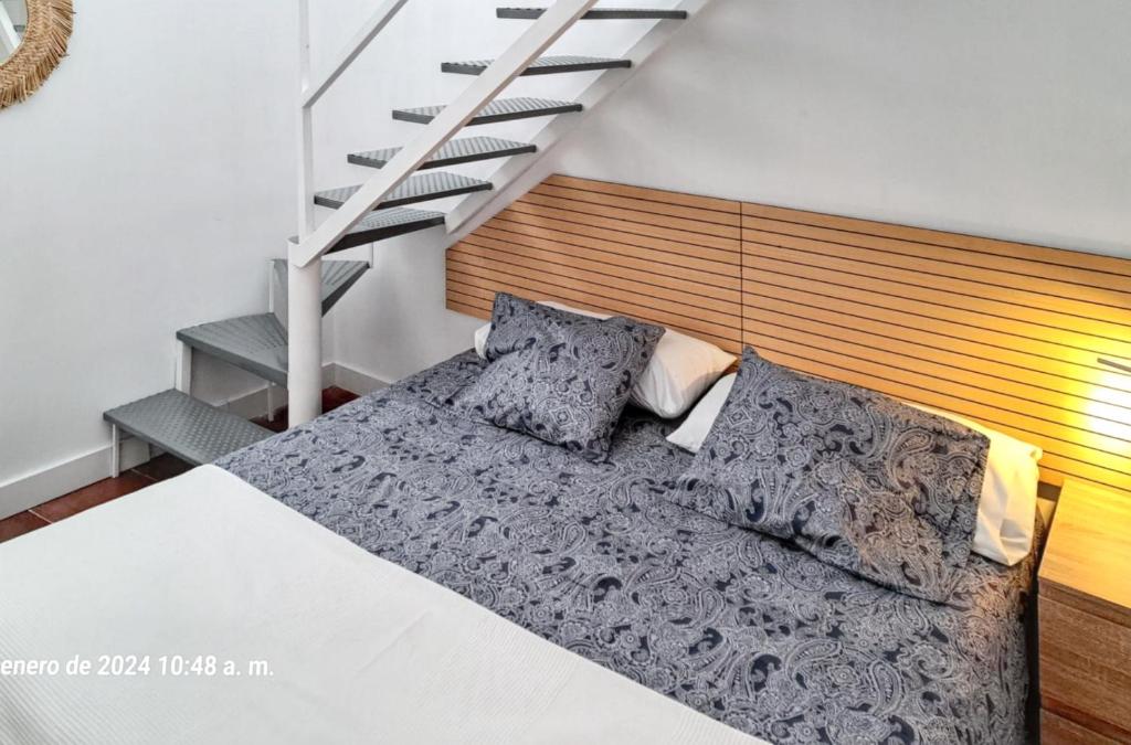 een slaapkamer met een bed en een trap bij Studio at Barbate 300 m away from the beach with furnished terrace and wifi in Barbate