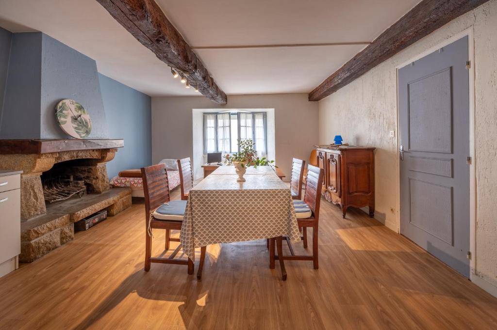 ein Esszimmer mit Tisch und Stühlen und einem Kamin in der Unterkunft Sarzeau centre - Le Cormoran in Sarzeau