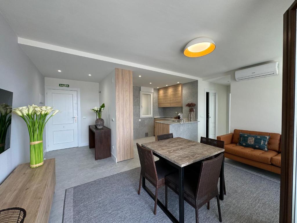 a kitchen and living room with a table and a couch at Apartamento Calas in Noja