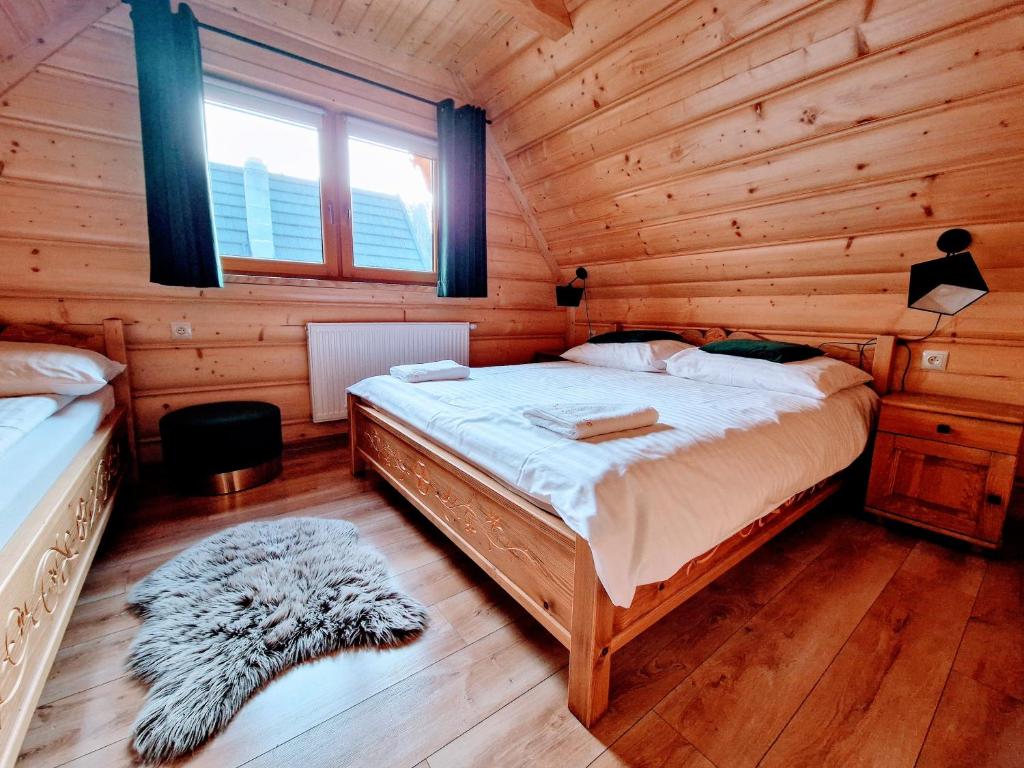 sypialnia z łóżkiem w drewnianym domku w obiekcie Domki Krupa Chochołów w Chochołowie