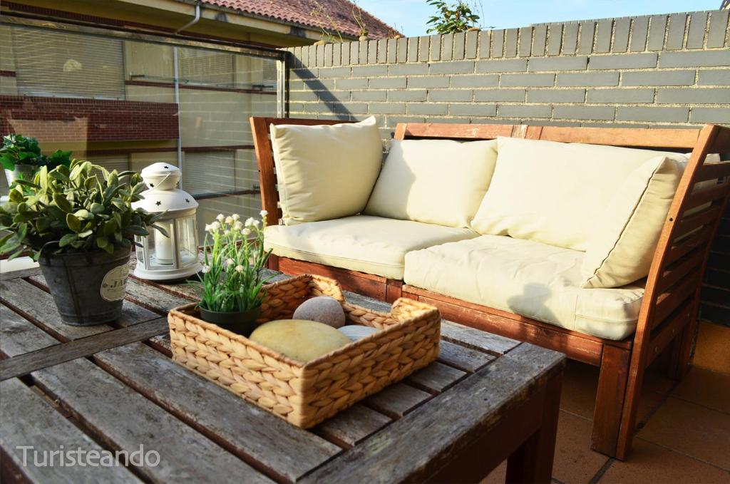 a couch sitting on top of a wooden table at La Casuca del Farolillo - con parking y terraza primera línea de playa in San Vicente de la Barquera