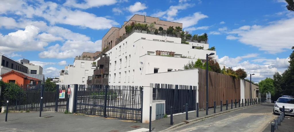 Un bâtiment blanc avec une colline au sommet dans l'établissement Une résidence à 30 minutes du coeur de Paris !, à Romainville