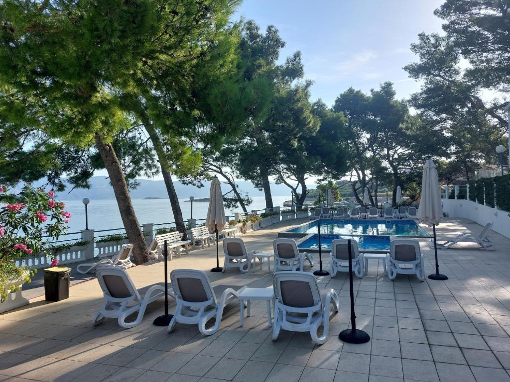a patio with a table and chairs and a swimming pool at Lumbarda, Korcula apartment near the beach in Lumbarda