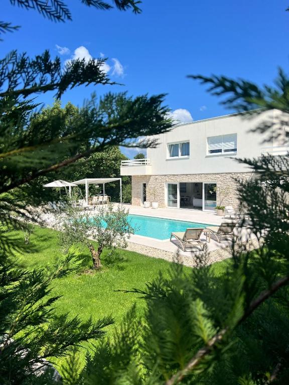 a large white house with a swimming pool at Villa Lu in Prkačini