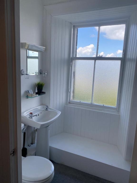 La salle de bains est pourvue d'un lavabo, de toilettes et d'une fenêtre. dans l'établissement Ellwyn House, à Édimbourg