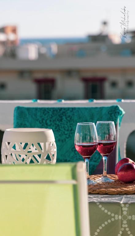 two glasses of red wine sitting on a table at Galini Apartments Ideal for family near the beach in Kalamaki Heraklion