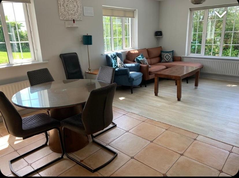 sala de estar con mesa y sofá en Hydrangea House en Kinsale