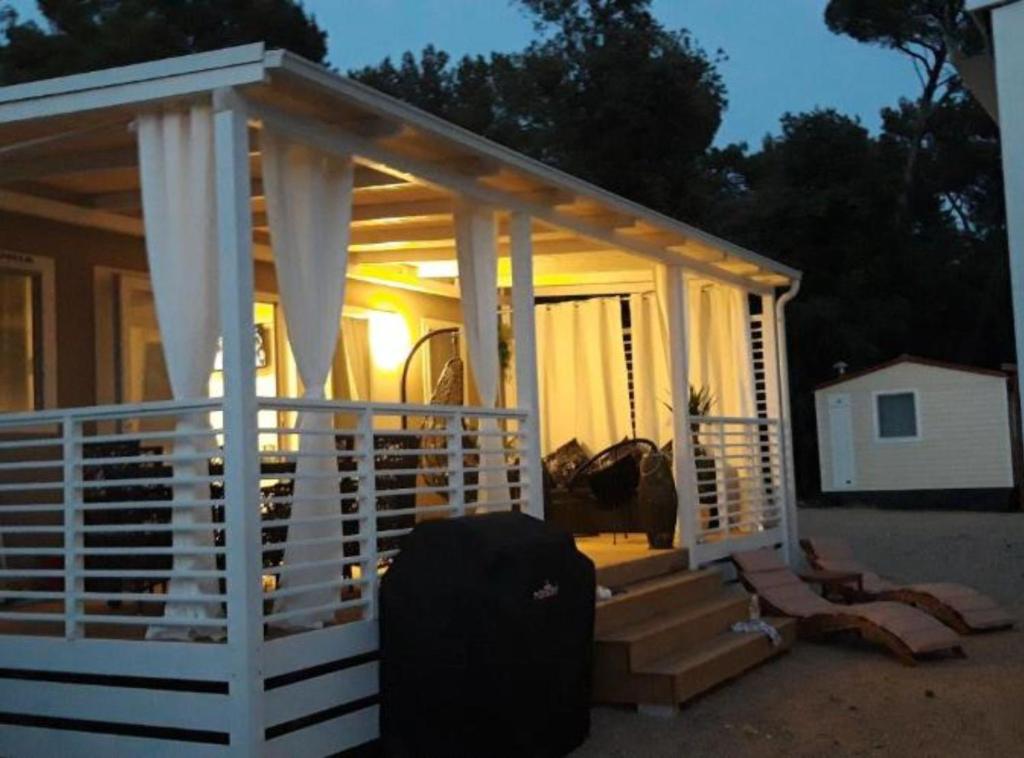 una piccola casa con portico e valigia di Mobile Home Nensi a Biograd na Moru