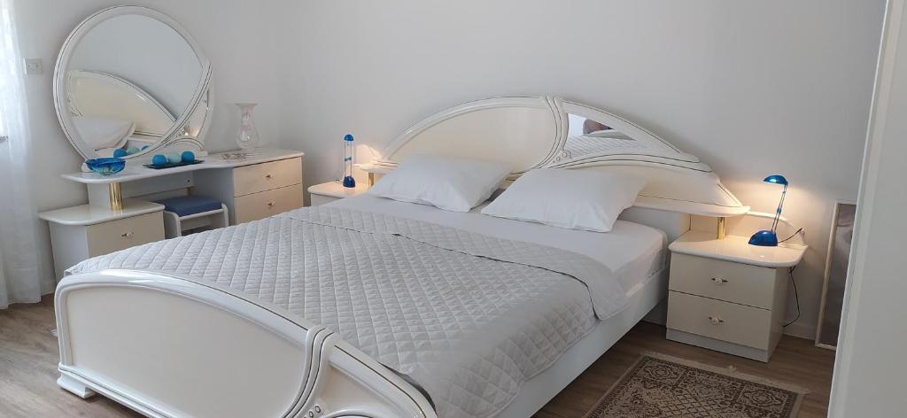 a bedroom with a white bed with two mirrors at More in Crikvenica