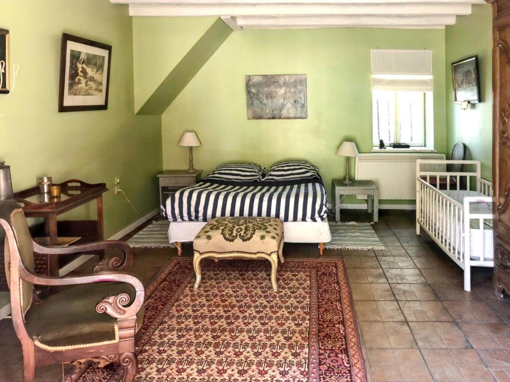 um quarto com uma cama e uma cadeira em Maison de 4 chambres avec jardin clos et wifi a Souvigny em Souvigny