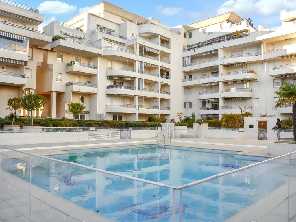 uma piscina em frente a um edifício em Appartement d'une chambre a Frejus a 300 m de la plage avec vue sur la ville piscine partagee et balcon em Fréjus