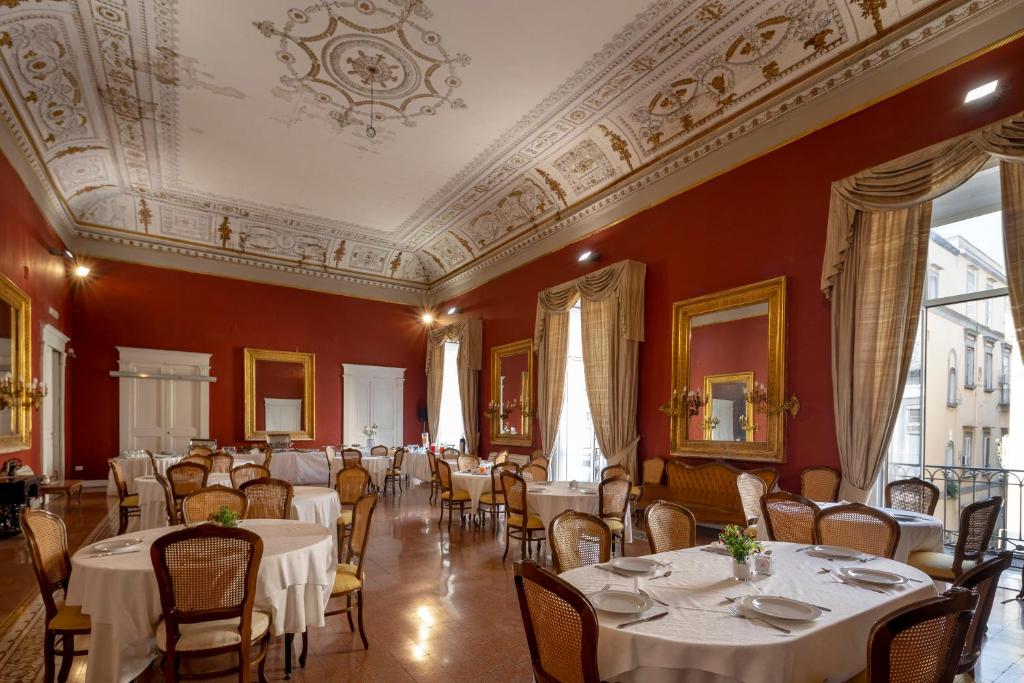 jadalnia ze stołami i krzesłami oraz sufitem w obiekcie Napolit'amo Hotel Principe w mieście Neapol