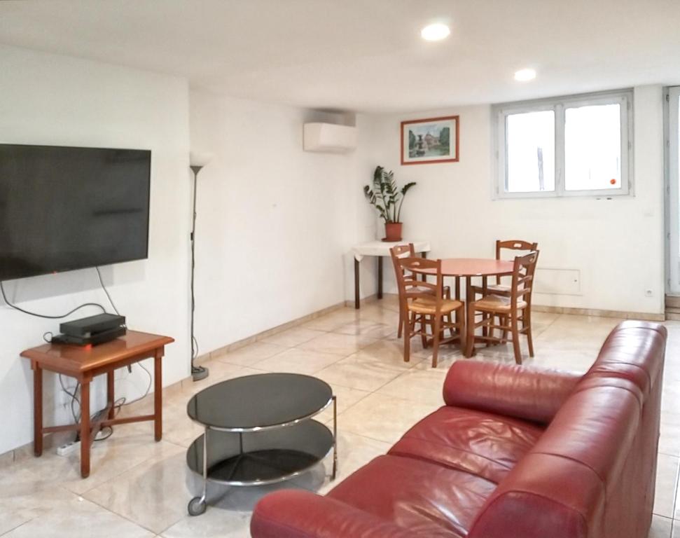 een woonkamer met een bank en een tafel bij Maison de 2 chambres avec jardin clos et wifi a Crouy sur Ourcq in Mary-sur-Marne
