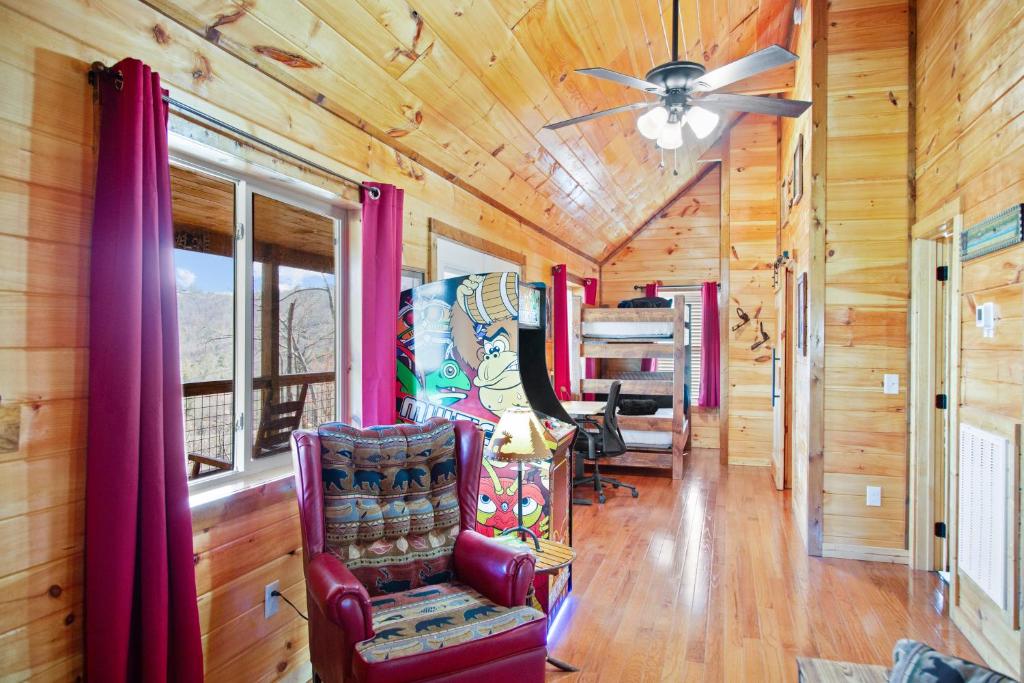 ein Wohnzimmer mit einem Deckenventilator und Stühlen in der Unterkunft Cabin In The Smokeys in Gatlinburg