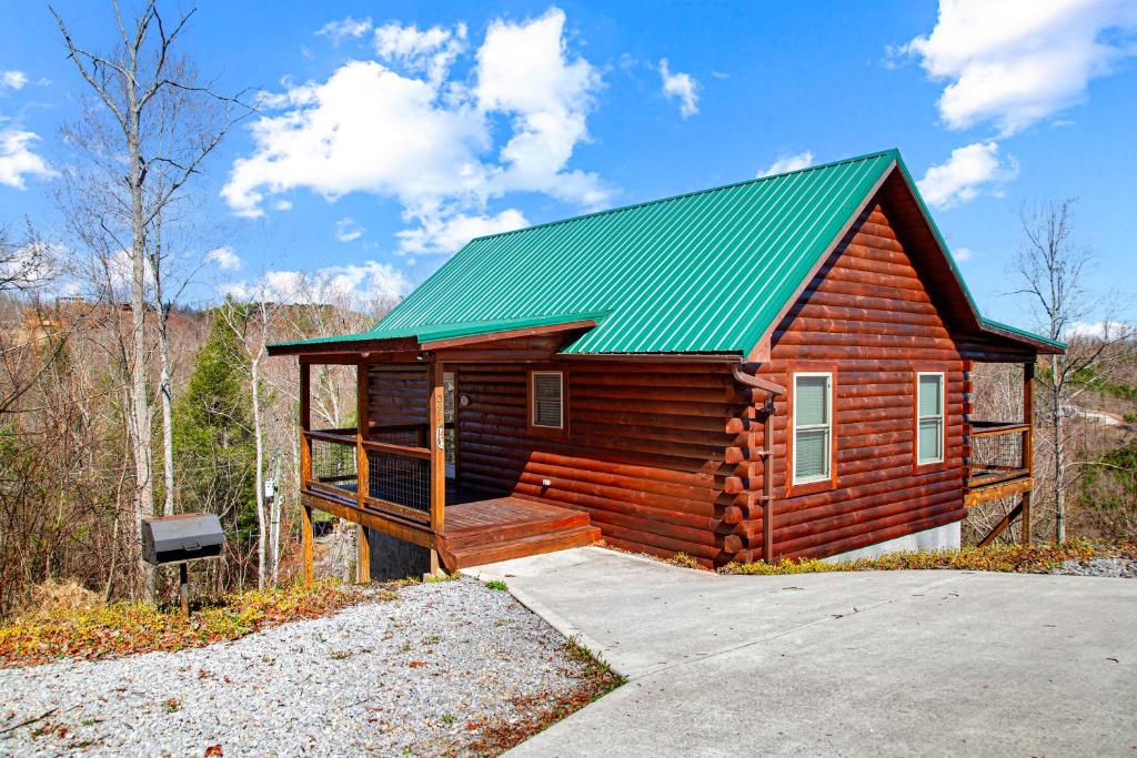 ein kleines Blockhaus mit grünem Dach in der Unterkunft Cabin In The Smokeys in Gatlinburg
