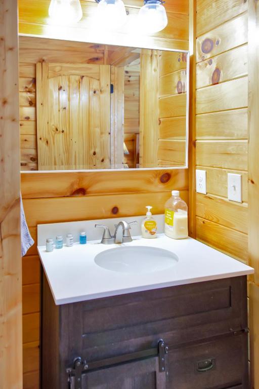 ein Badezimmer mit Waschbecken und Spiegel in der Unterkunft Cabin In The Smokeys in Gatlinburg