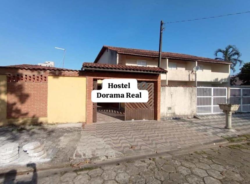 une maison avec un signe qui lit le drame hospitalier dans l'établissement Hostel Dorama Real, à Mongaguá