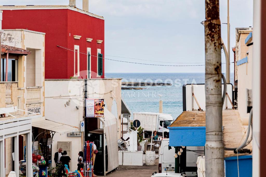 Une rue avec des bâtiments et l'océan en arrière-plan dans l'établissement CENTRAL SQUARE - San Foca, à San Foca
