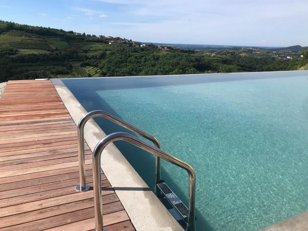 a swimming pool with a metal handrail on a wooden deck at Enam Room in Kojsko